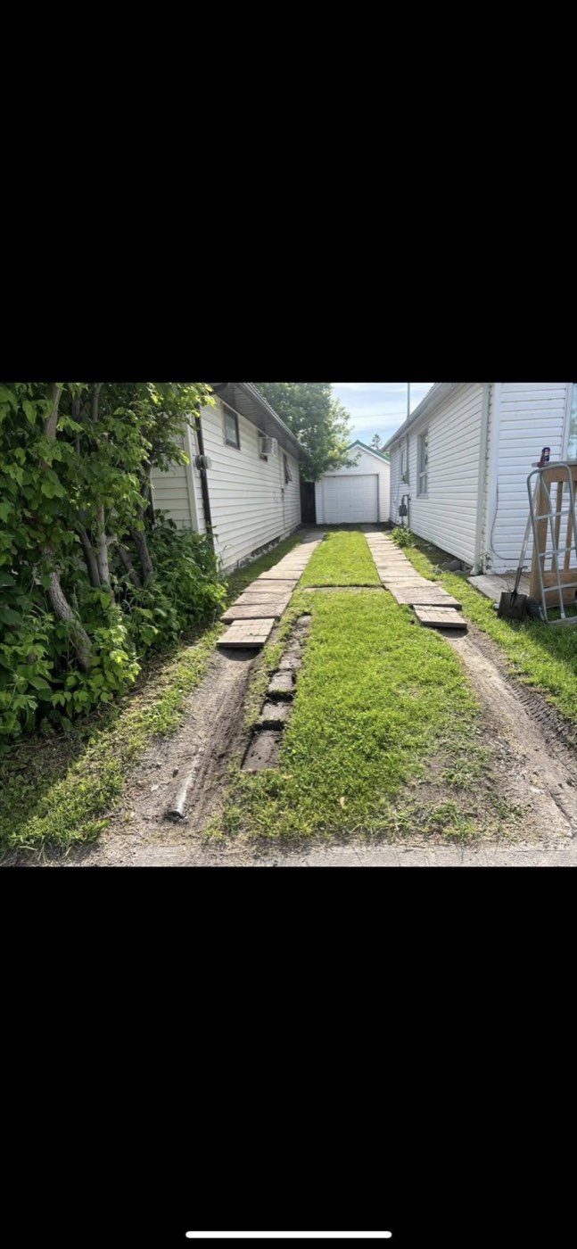 Rutted, grown-over driveway before repair